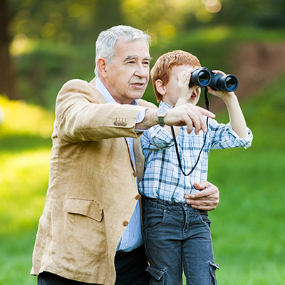 grandpa with his grandson looking through binoculars