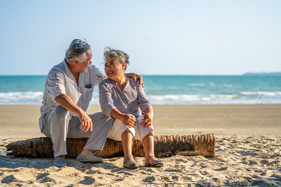 senior couple sitting on the beach together life insurance for retirement